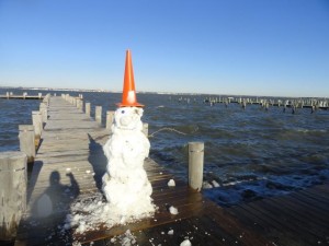 A snowman stands guard over the flooded public pier at Second Street and the bay on Sunday.