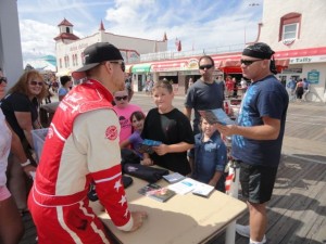 Jason Flood, who survived a banner plane crash several years ago to become a top-notch stunt pilot, signs autographs on the boardwalk after his performance.