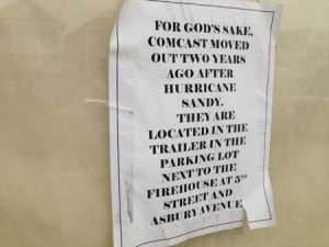 A sign on the door of Comcast's former location at 341 West Avenue steers customers to the temporary trailer.