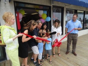 Mayor Jay Gillian helps a couple of young customers cut the ribbon on the new Bowfish Kids on Friday as owner Caitlin Quirk (second from right) watches.