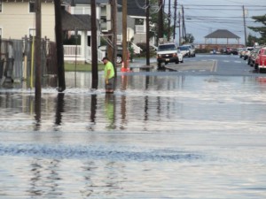 A Shoemaker Lumber employee assesses the depth of the water near the intersection of 12th Street and West Avenue on Thursday morning.