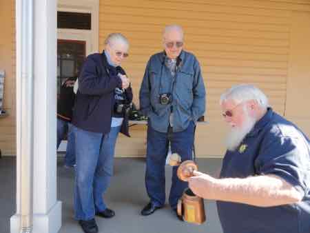 U.S. Life Saving Station 30 Chairman John Loeper demonstrates the use of a kerosene-fueled torch to visitors completing the Lighthouse Challenge on Saturday.