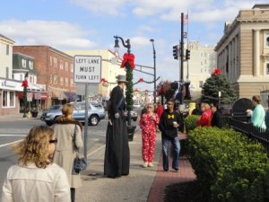 A stiltwalker chats with Earlier Than the Bird shoppers on Saturday morning in Ocean City.