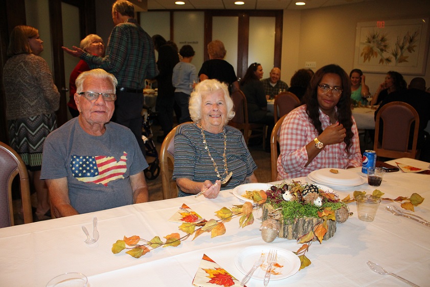 Jack Baldwin, Irene Dickey and Tamika Cortez enjoy the pot luck dinner Saturday at Gardens Plaza.