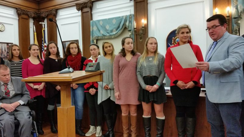 Council Vice President Tony Wilson reads a city proclamation in honor of the state championship Ocean City High School field hockey team.