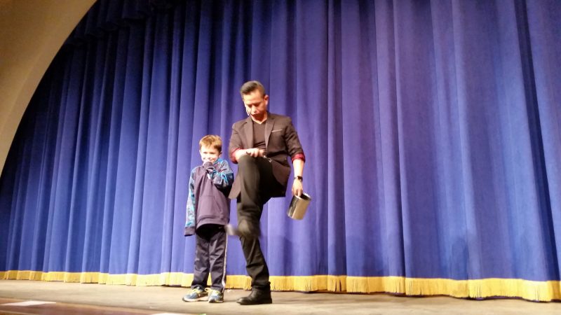 Ryan Kelly, 7, helps illusionist Anthony Salazar perform a magic trick during a show at the Music Pier.