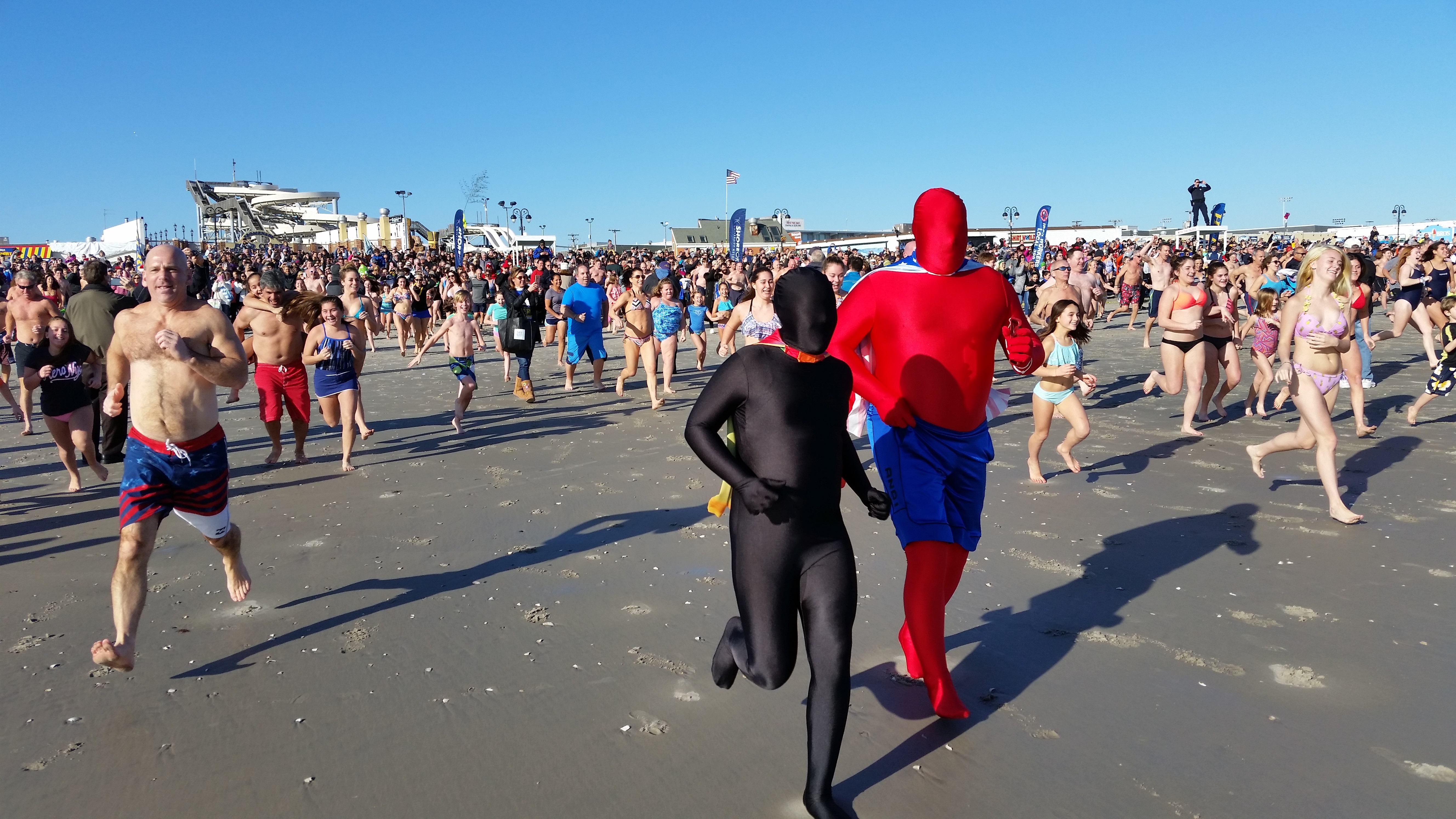 Clad in his red and blue superhero costume, veteran First Dip plunger Brian Green, of Ocean City, charges for the surf.