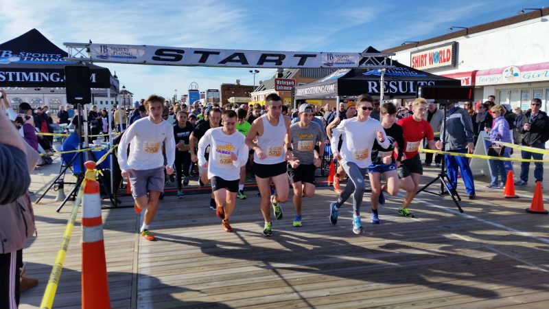 Ocean City High School track star Jesse Schmeizer, at right in white top and sunglasses, dominated the First Day 5K race on the Boardwalk.